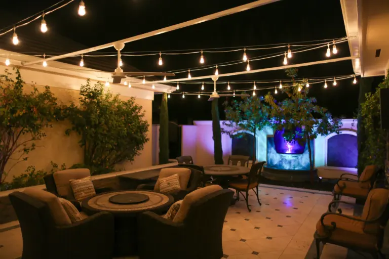 Backyard lounge with string lights and illuminated trees