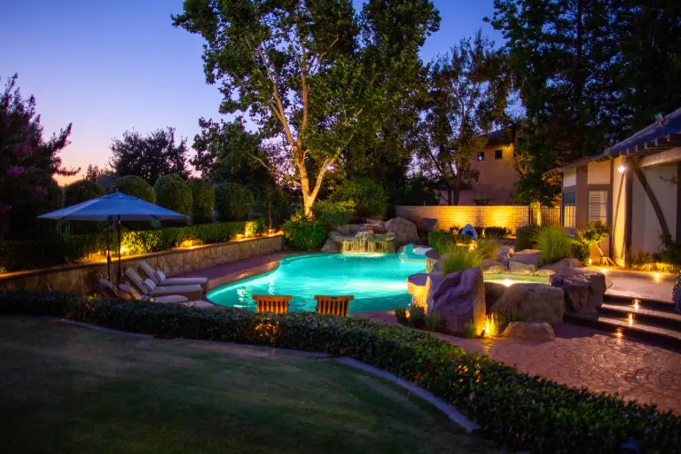 Pool surround with tree, wall, step, and garden lighting